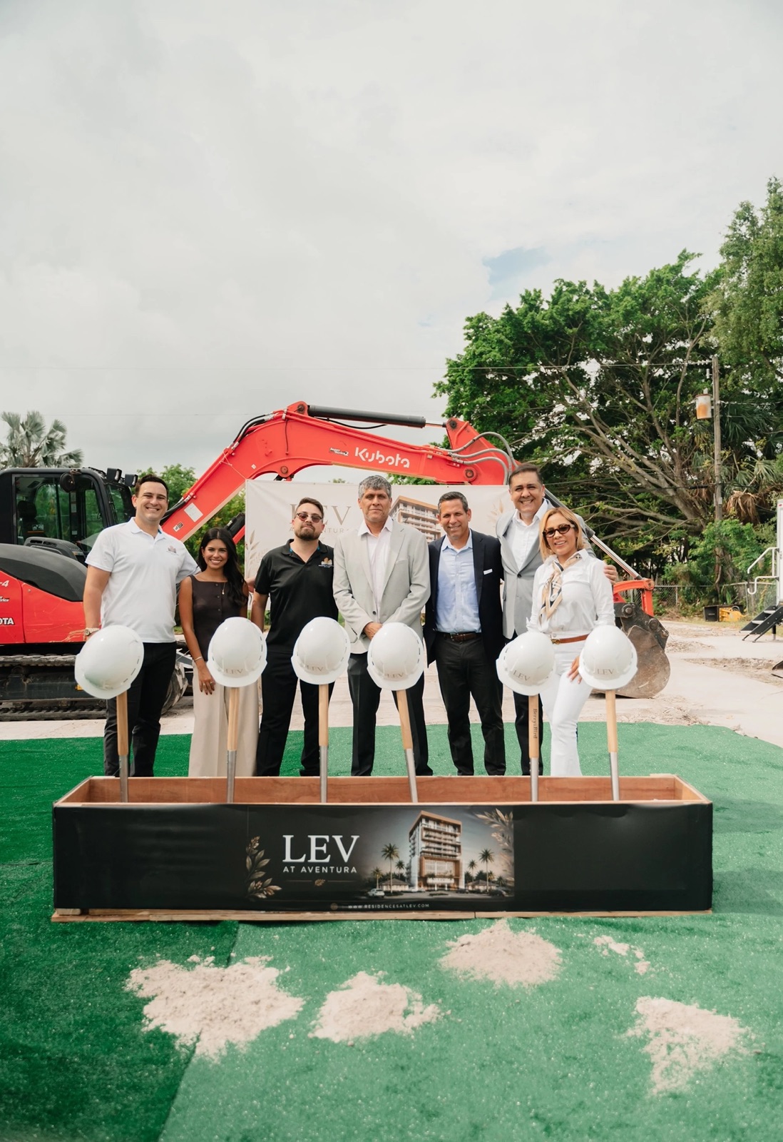Growin Group team at the June 2026 groundbreaking of LEV at Aventura, with the project rendering on the ceremonial sand box