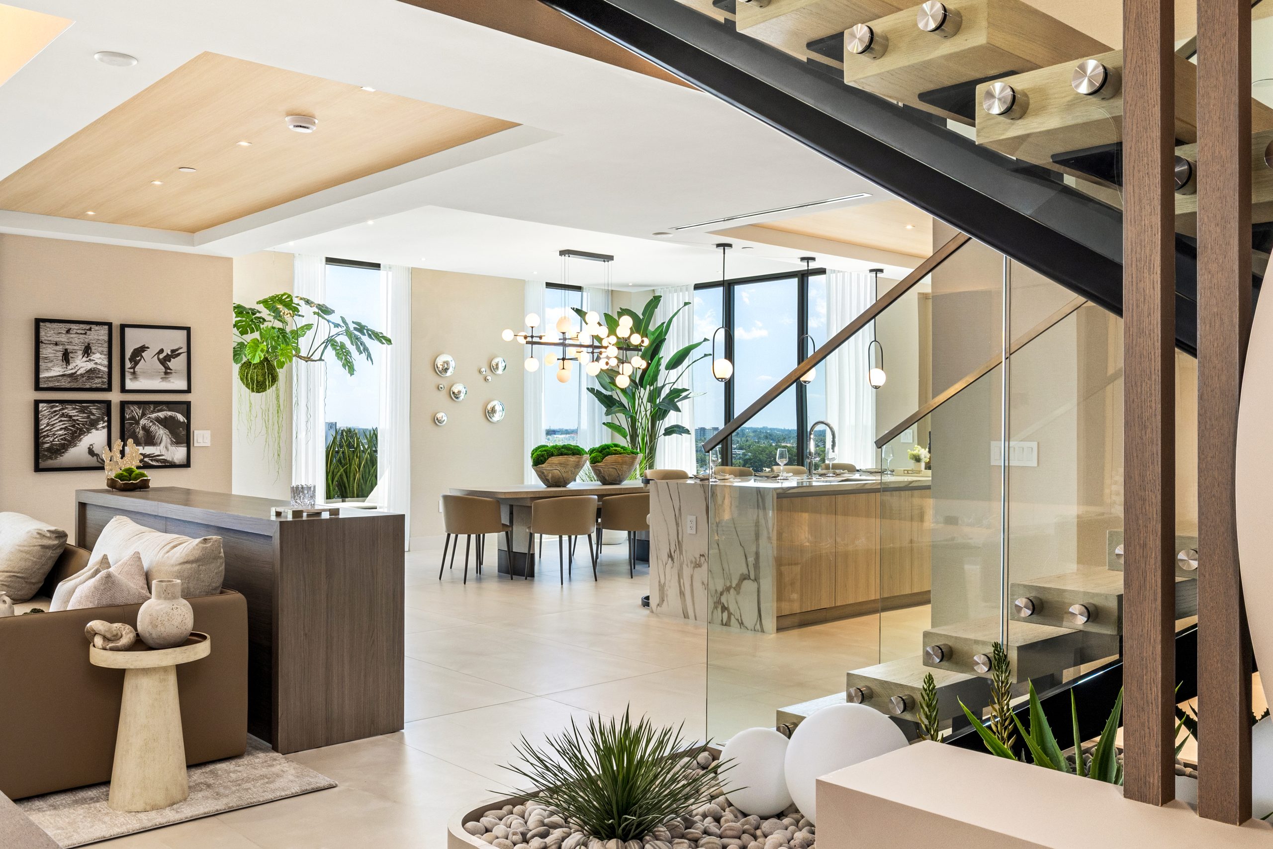 Salato Pompano Beach penthouse living and dining area with floating staircase and marble waterfall island