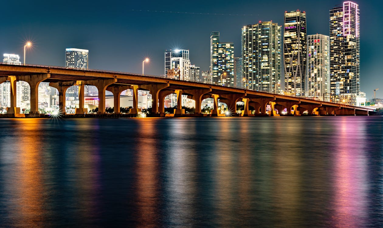 Miami skyline lit up at night over Biscayne Bay, reflecting the nightlife identity behind music-branded residences