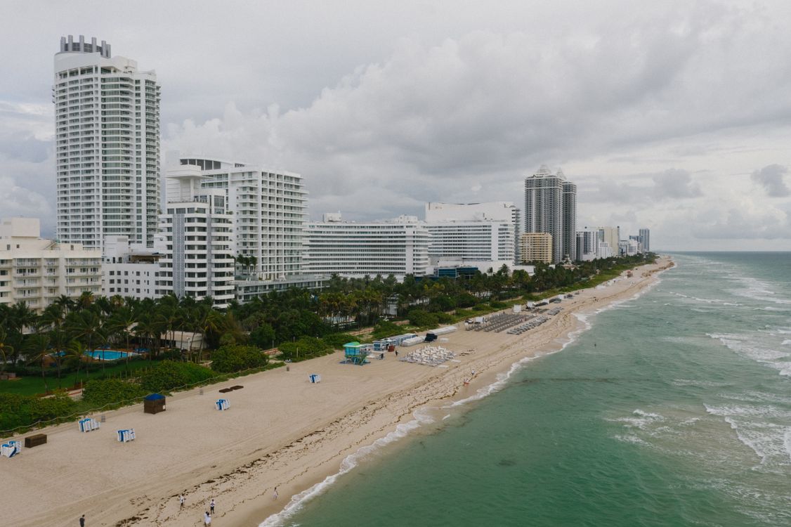 Aerial of Mid-Beach oceanfront luxury condo towers along Collins Avenue with the beach and Atlantic, the heart of Miami Beach's Millionaire's Row