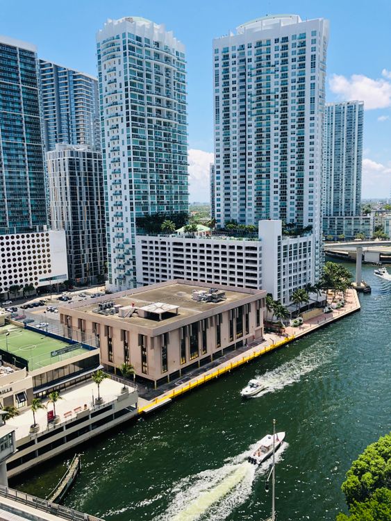 Brickell waterfront condo towers along the Miami River where 2026 insurance reductions ease HOA master policies