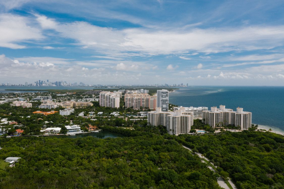 Aerial view of a Miami island residential community with the downtown skyline behind it
