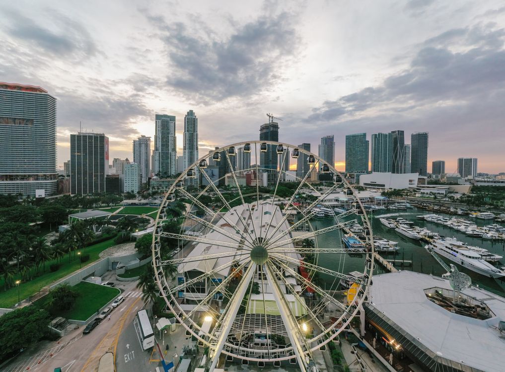 Aerial view of downtown Miami with the bayfront observation wheel and condo towers, the urban core just south of the Midtown neighborhood where The Standard Residences completed in 2026