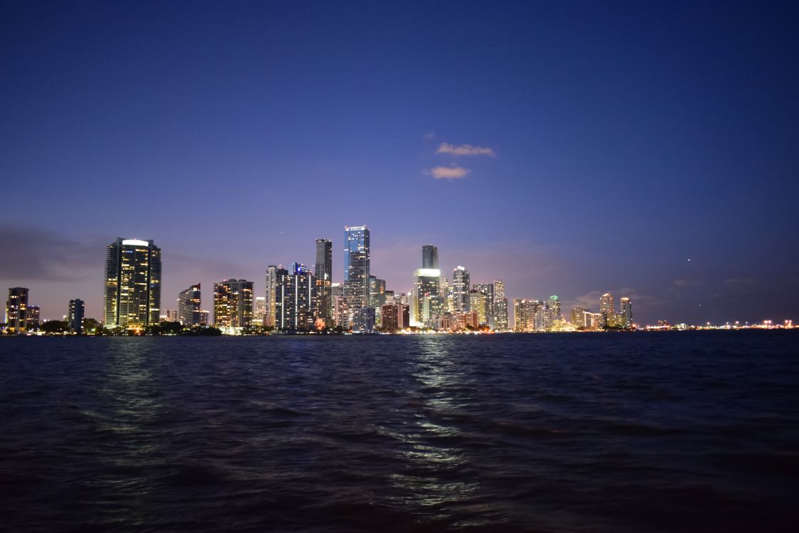 Miami skyline at dusk over Biscayne Bay, the downtown and Brickell luxury market drawing relocating California buyers ahead of the 2026 wealth tax vote