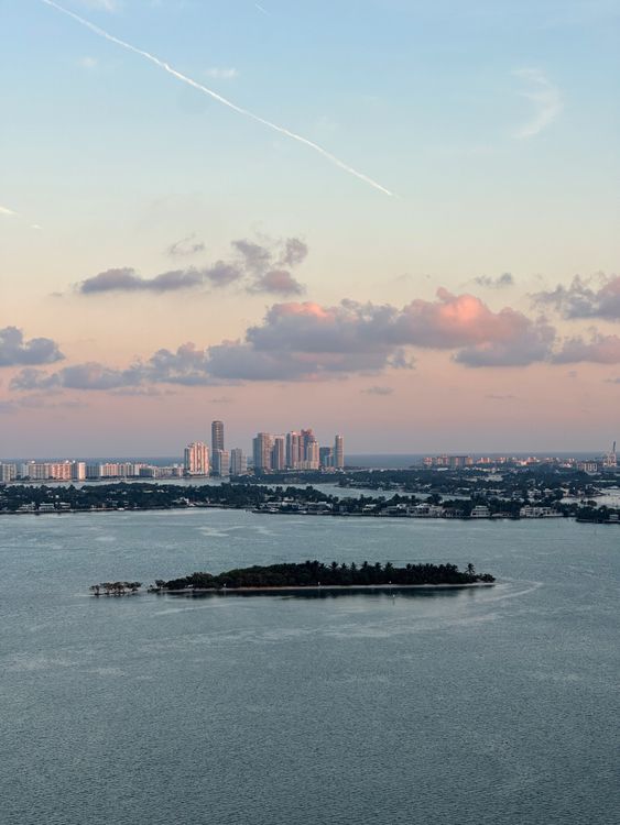 Aerial view of Miami's bay islands and skyline at sunset, the trophy waterfront market that tightens as relocating California billionaires buy in