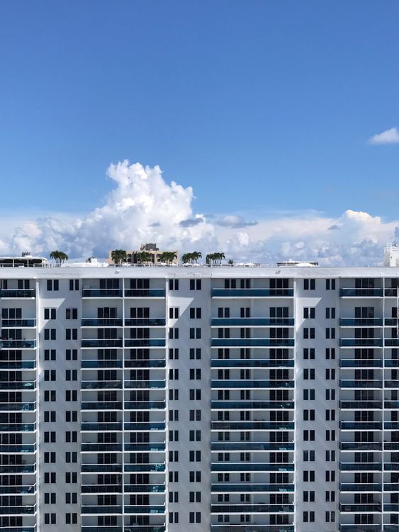 A white Miami oceanfront condo tower under a blue sky, the newer construction that insures more cheaply than older 1970s and 1980s buildings