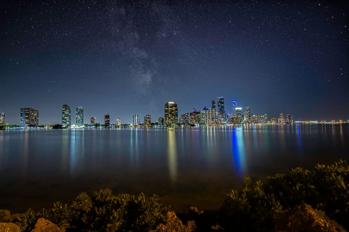 Miami downtown skyline over Biscayne Bay at night, the market where a strong dollar is reshaping what foreign buyers pay for luxury condos in 2026