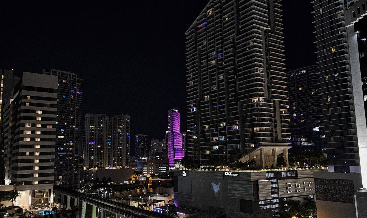 Brickell luxury condo towers lit at night with the Miami skyline, representing capital locked in preconstruction deposits until delivery