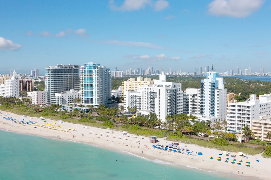 Aerial view of oceanfront luxury condo towers along Collins Avenue in Miami Beach