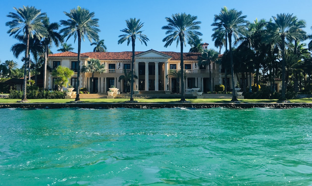 Waterfront estate with palm trees on a Miami Beach island seen across Biscayne Bay