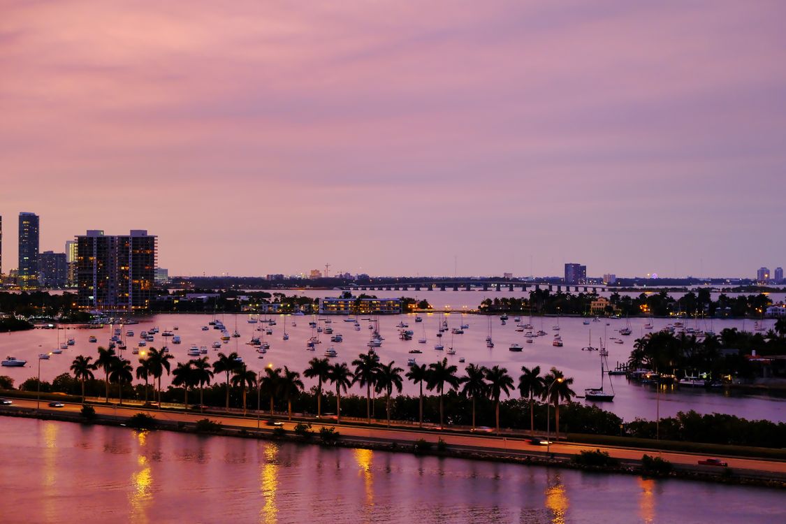 Biscayne Bay at dusk with moored yachts and the Miami waterfront skyline beyond