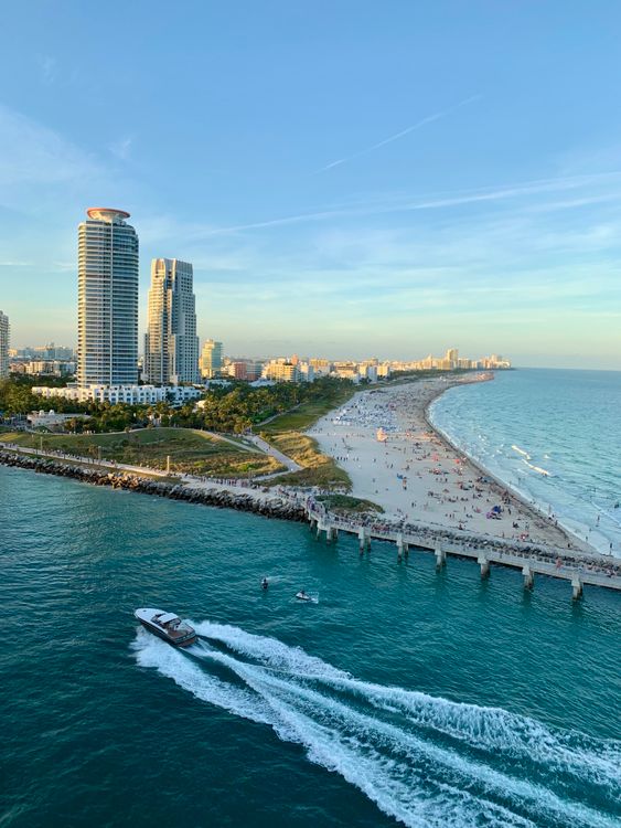South Beach shoreline with the South Pointe towers, the beach, and a boat cutting through Government Cut in Miami