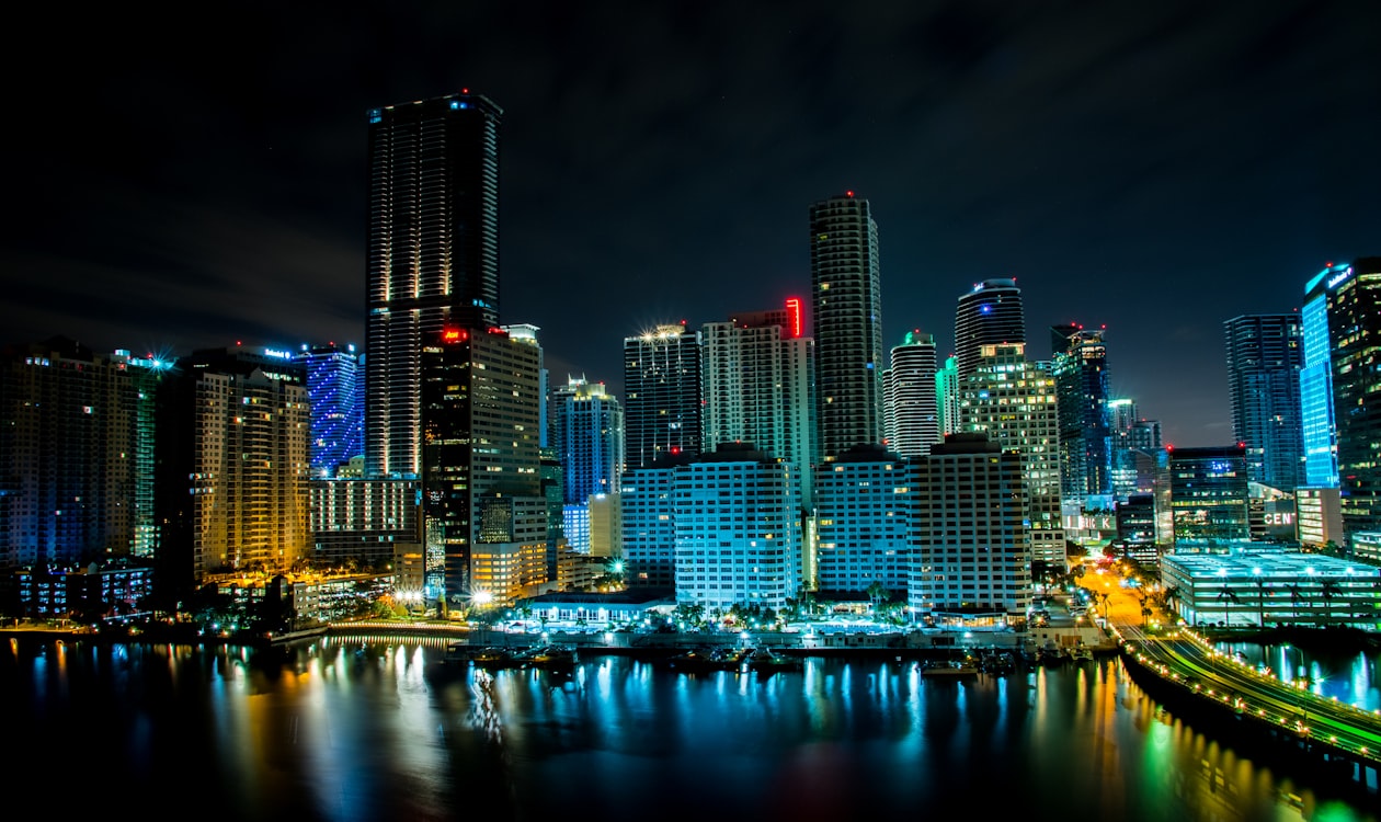 Brickell Key and Biscayne Bay lit at night in Miami, the submarket drawing international condo buyers