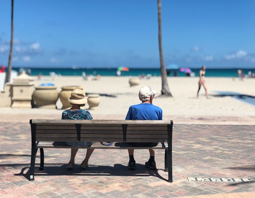 Couple on a bench along the Hollywood Beach Broadwalk promenade facing the Atlantic Ocean