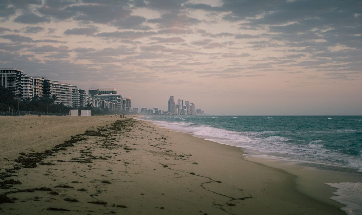 Miami Beach shoreline at twilight with oceanfront condo towers along the coast