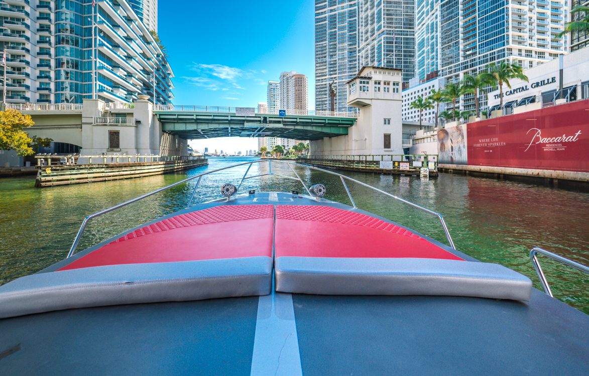 Boat on the Miami River passing under the Brickell Avenue bridge between condo towers in Miami Florida