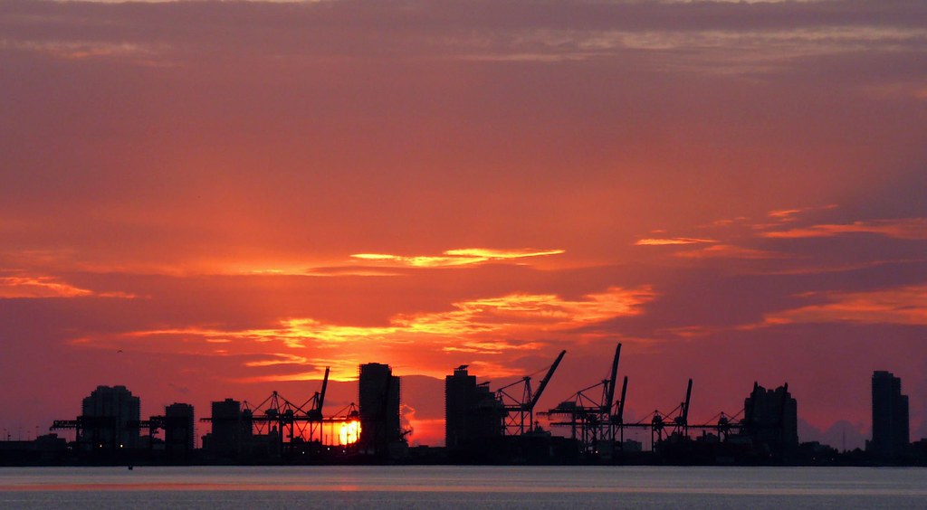 Silhouetted Miami skyline and Port of Miami at sunset seen from Miami Beach across Biscayne Bay