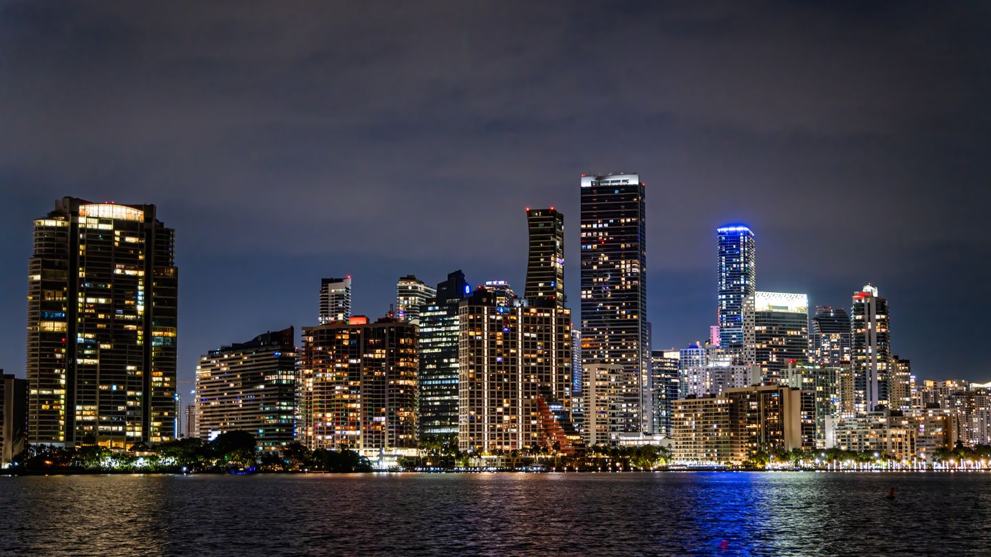 Best Miami pre-construction luxury condo towers lit up along the Brickell skyline over Biscayne Bay at night in 2026