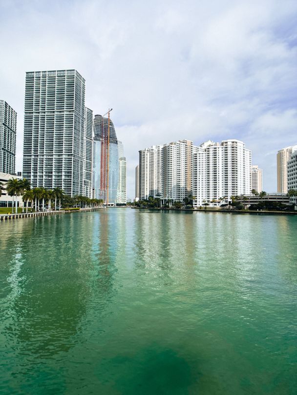 Brickell Key waterfront luxury condo towers over green Biscayne Bay water in Miami