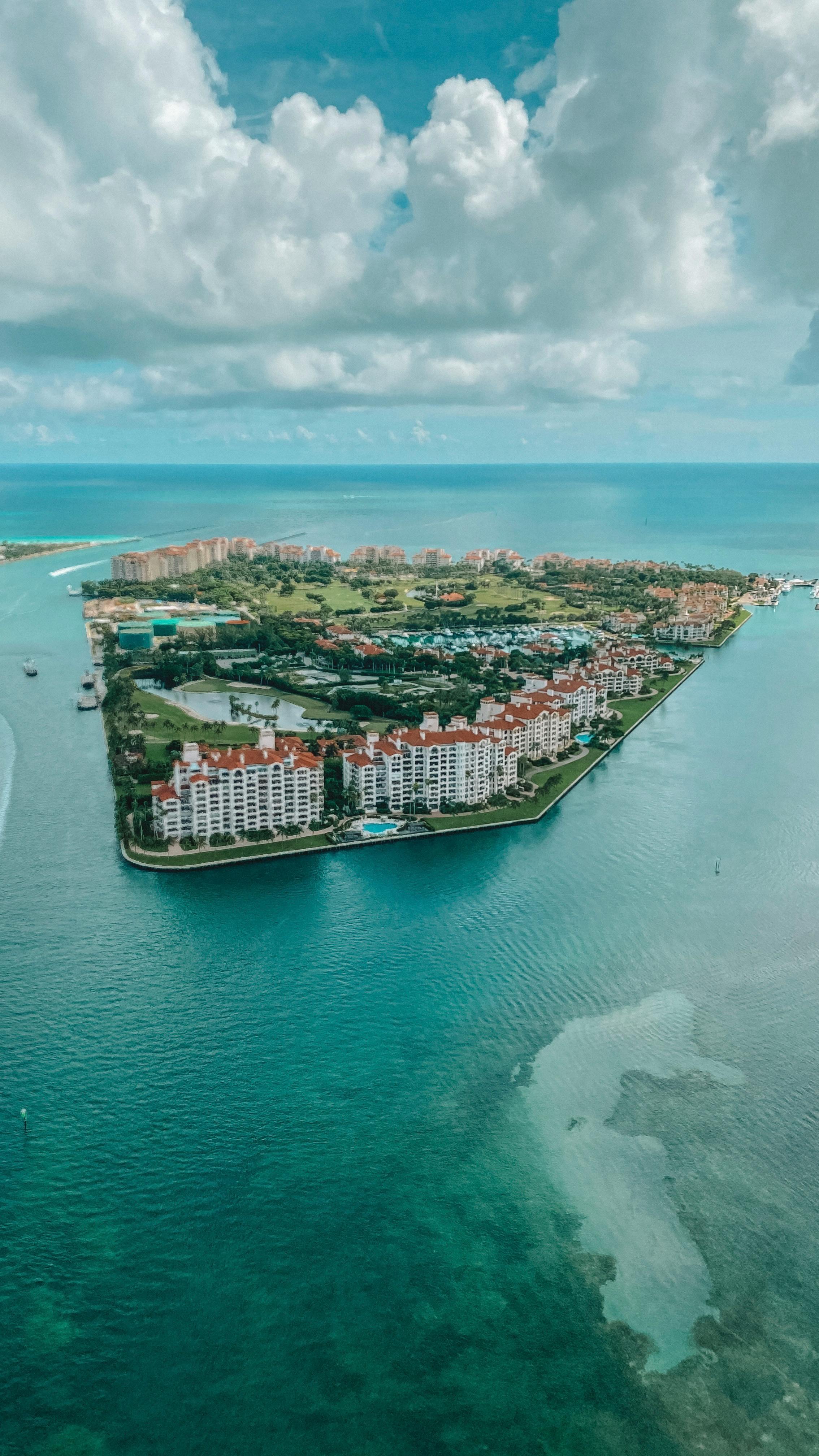 Aerial view of Fisher Island Miami private barrier island surrounded by turquoise Biscayne Bay water