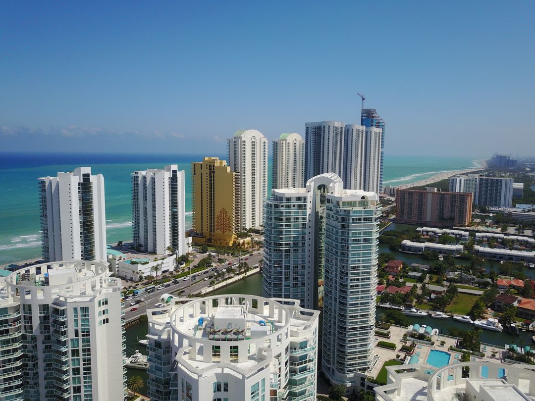 Sunny Isles Beach oceanfront condo towers with a construction crane rising above Collins Avenue