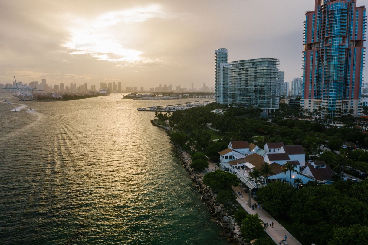 South Pointe Park and Miami Beach bayfront condominium towers at sunset with PortMiami and the downtown skyline behind