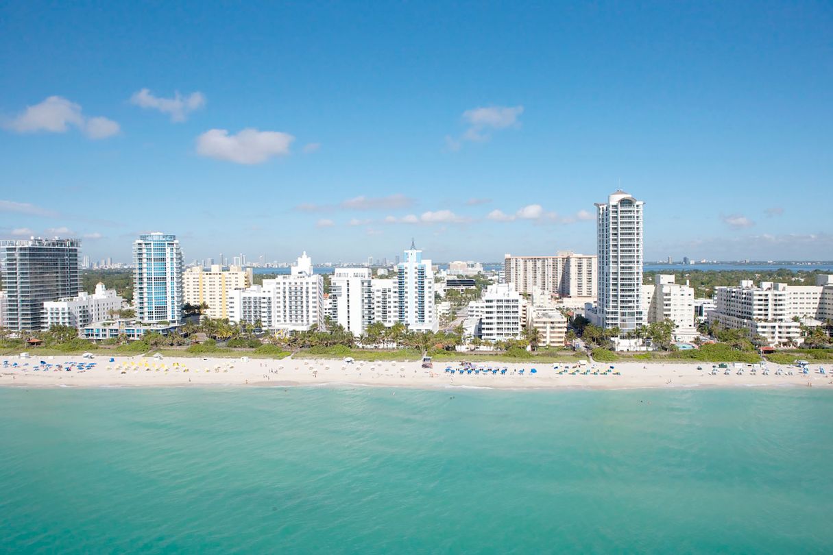 Aerial view of the Miami Beach oceanfront condo tower wall with the mainland Miami skyline behind