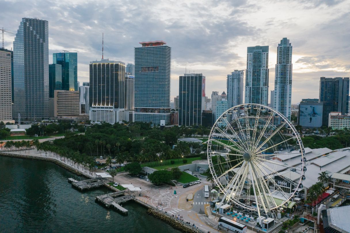 Aerial of downtown Miami bayfront with luxury condo towers and the observation wheel over Biscayne Bay