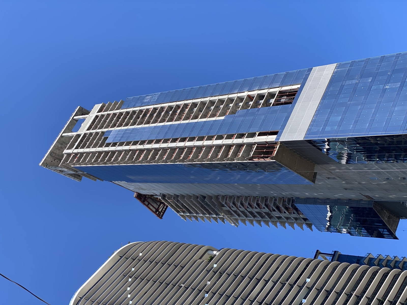Miami condo tower going vertical with glass curtain wall climbing the concrete frame