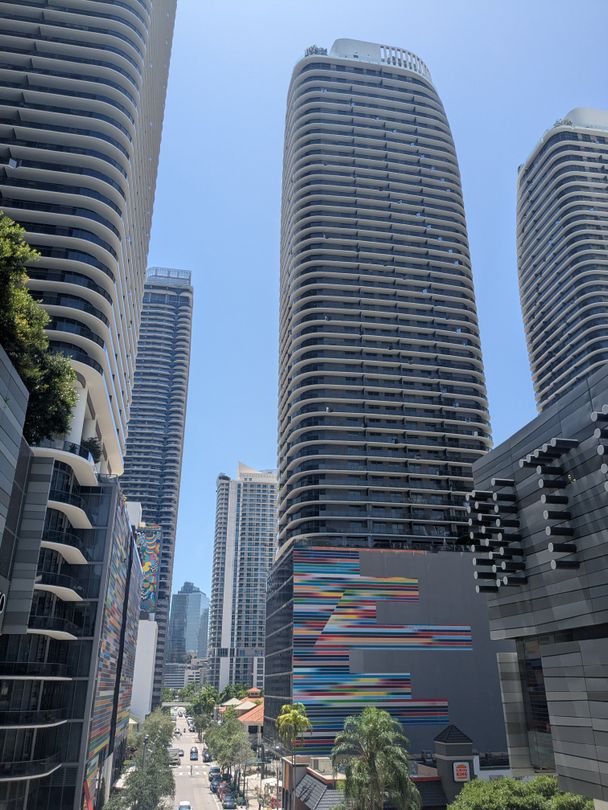 Brickell luxury condo towers with curved balconies, daytime street view in Miami