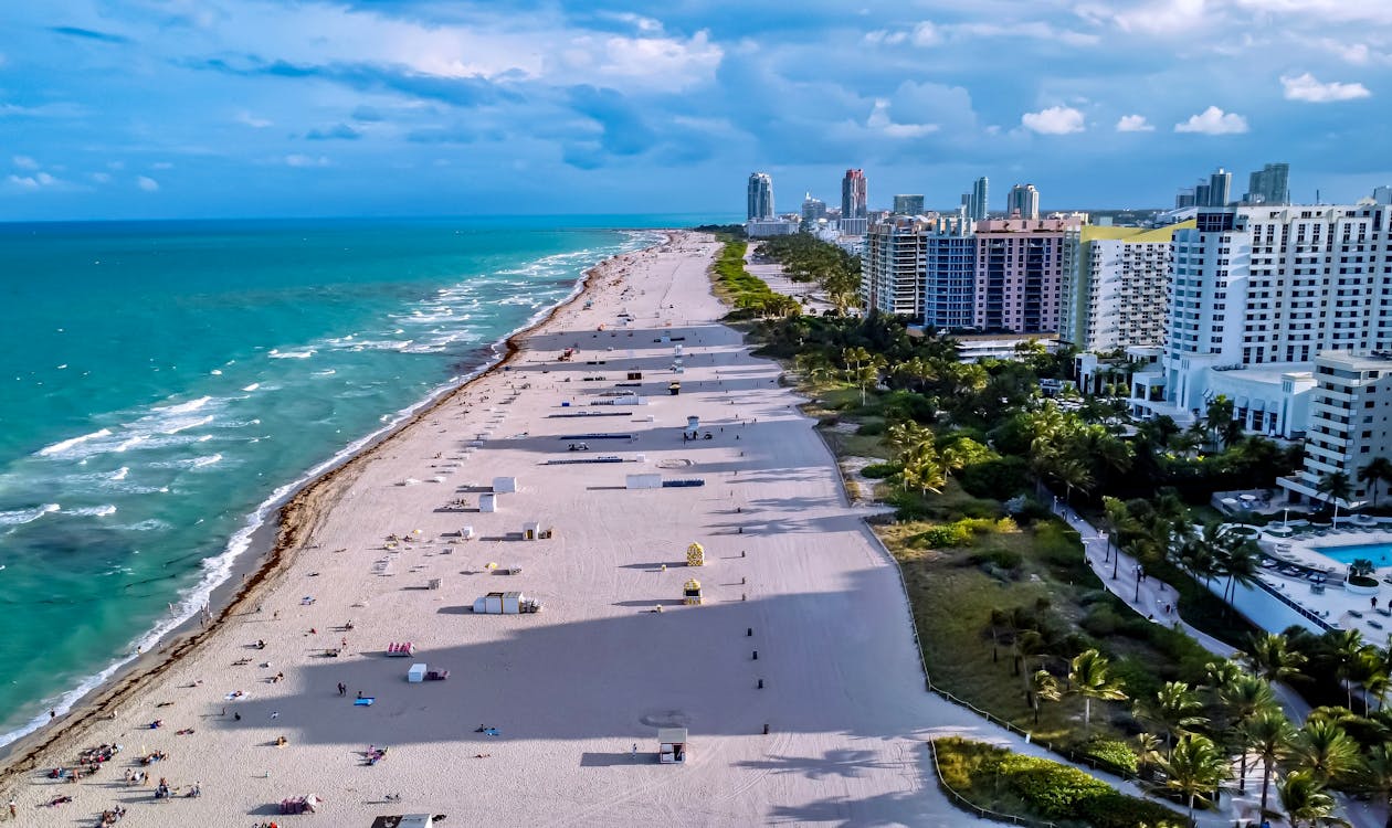 Aerial view of Mid-Beach Miami with wide sandy beach, turquoise Atlantic Ocean, and luxury hotel towers