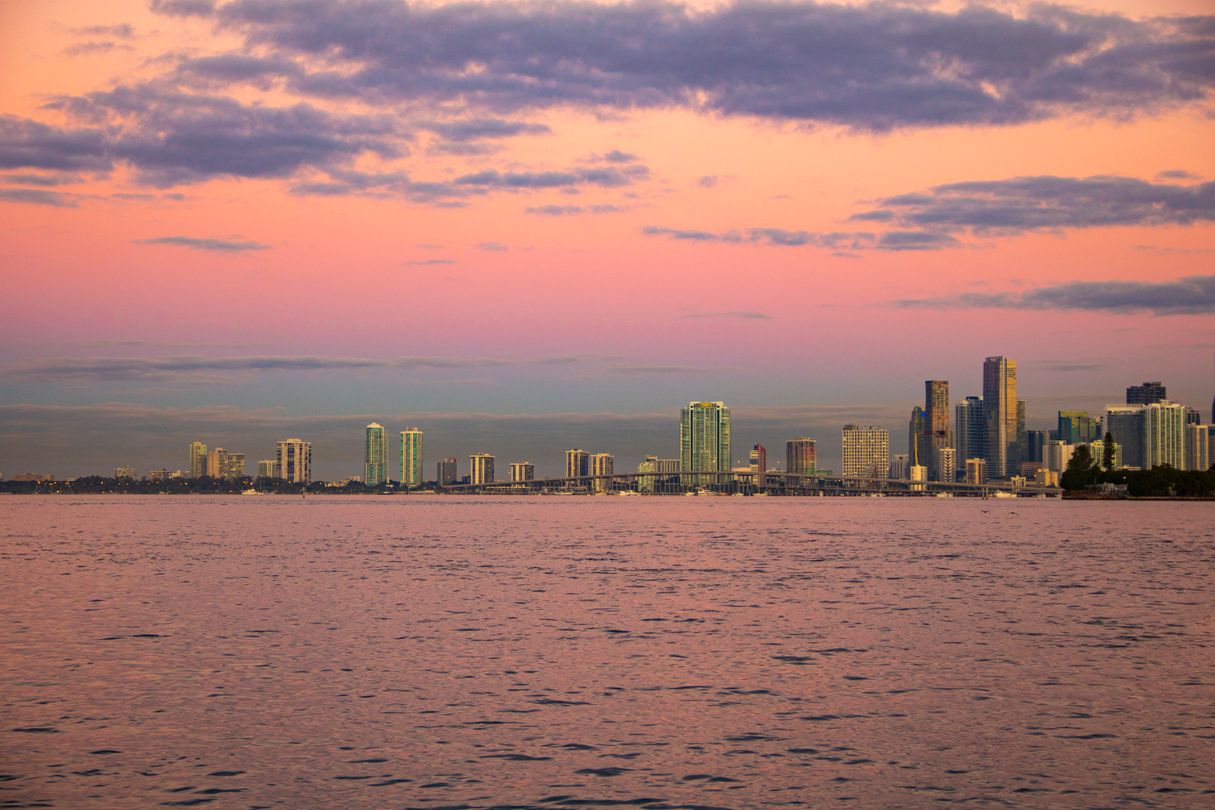 Miami skyline at sunset with pink sky over Biscayne Bay and distant condo towers