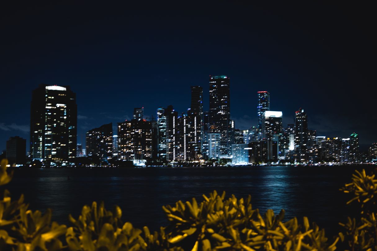 Miami-Dade new construction condo towers and skyline at night across Biscayne Bay, 2026 pre-construction pipeline